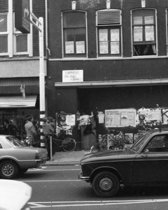 835032 Afbeelding van een opgehitste jongere die een vruchteloze poging doet om het gekraakte voormalige winkelpand van ...